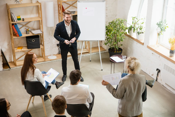 男演讲人在车间大厅演讲。观众或会议厅。未被认出的参与者的高角度。图片下载