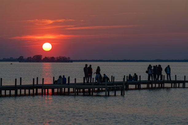 在日落的气氛中，码头上人们的剪影图片下载