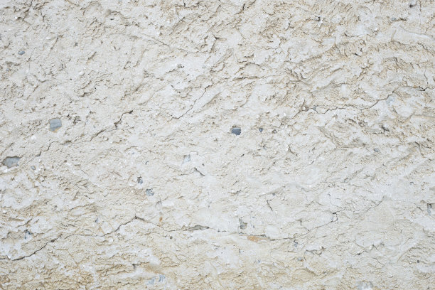 灰色水泥墙的底部已经被时间磨损了。图片下载