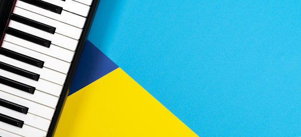 俯视图钢琴黄色和蓝色的背景。音乐学习的概念。俯视图图片下载