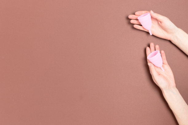 手拿月经杯。极简的零浪费概念与地方的文本。图片下载