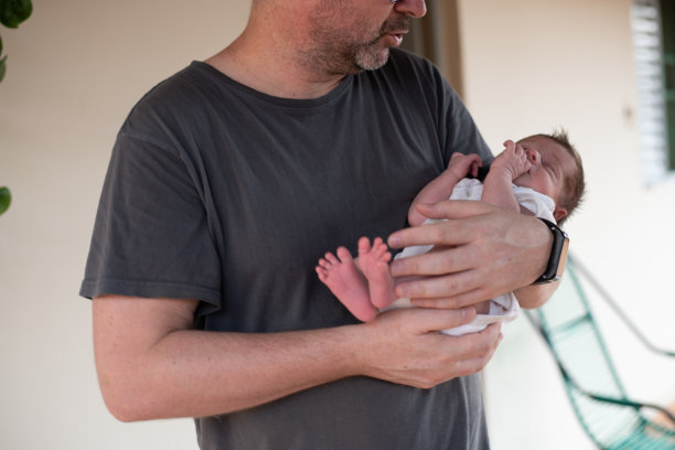 孩子在爸爸的腿上。图片下载