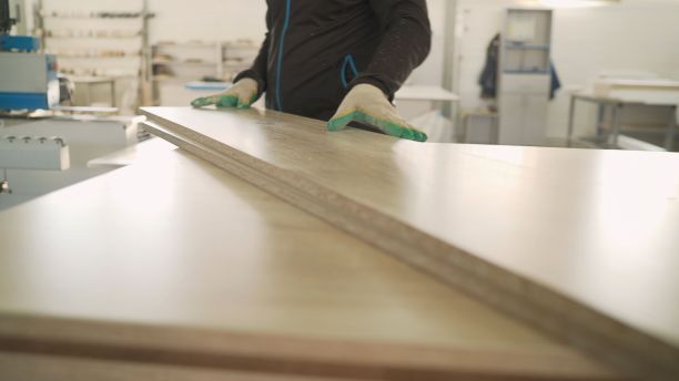 细木工。木工、木工生产。家具制造。在家具制造中的木板上钻孔。图片下载