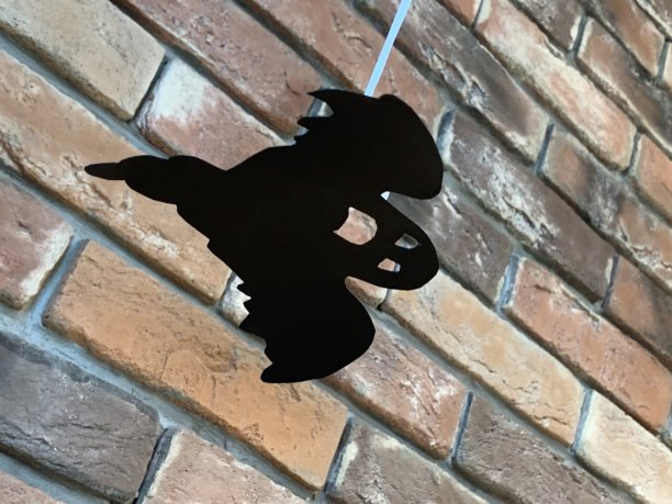 一个黑色的塑料小鬼像挂在砖墙上的天花板上图片下载