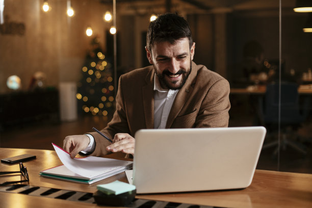 年轻的商人在办公室用笔记本电脑工作。图片下载