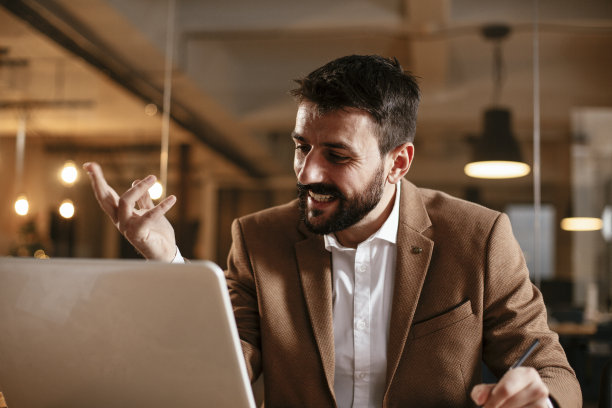 年轻的商人在办公室用笔记本电脑工作。图片下载