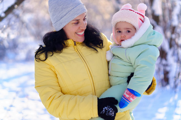 全家福在冬天的森林里，妈妈和孩子，明亮的阳光和雪地上的阴影，美丽的大自然图片下载