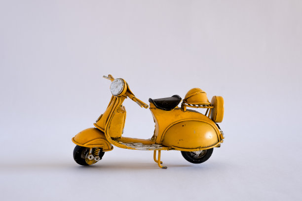 旧玩具摩托车在不同的背景图片下载