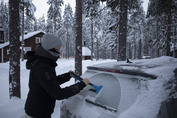 一个女人在清理车上的雪图片下载