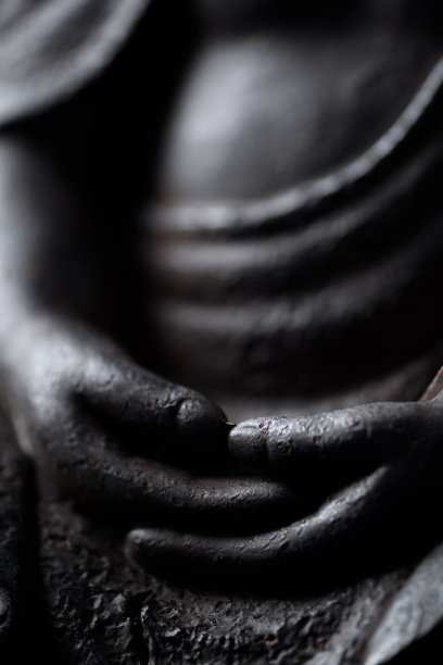 沉思佛像的双手孤立在黑色背景上。图片下载