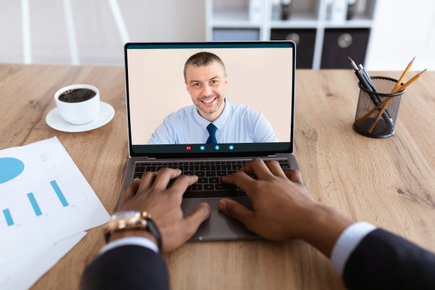 一个不知名的黑人商人用笔记本电脑和助理在线聊天图片下载