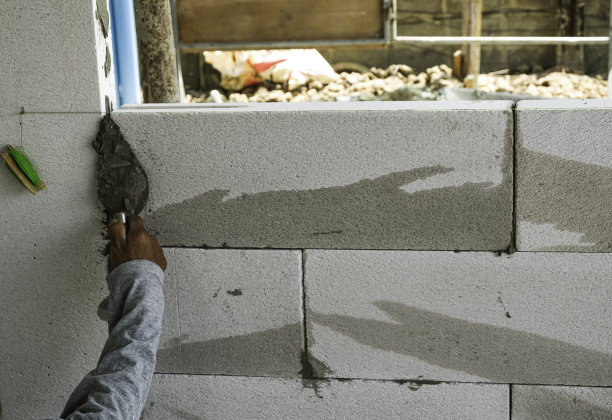 女工们用手抹刀砌墙回家。白色轻质混凝土砖砌体，砂浆水泥作灰泥。图片下载