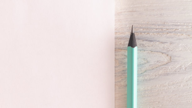 一种由黑色、木质、薄荷色或绿松石色制成的铅笔，旁边有一张白纸图片下载