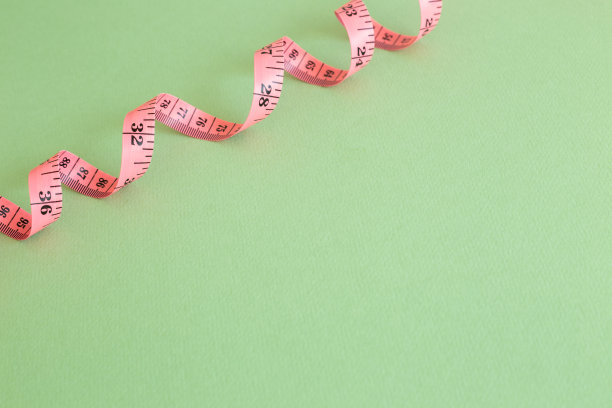 绿色背景上的粉色卷尺图片下载