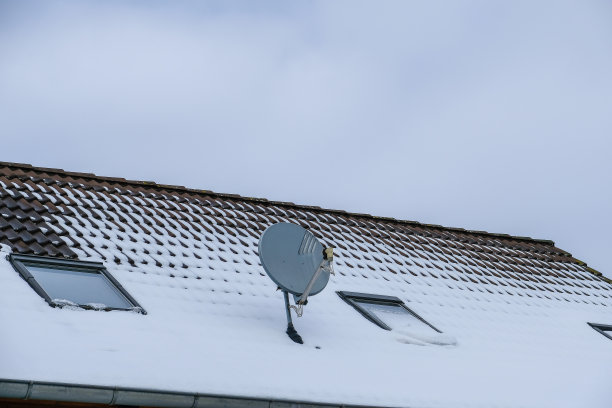 旧电视或者被雪覆盖屋顶上的电视天线图片下载
