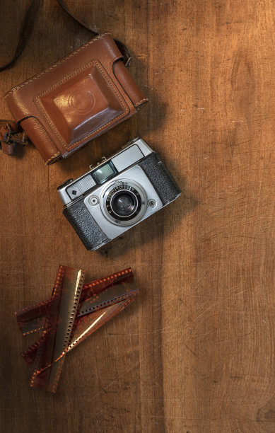 静物平躺的复古相机与底片在木制背景上图片下载
