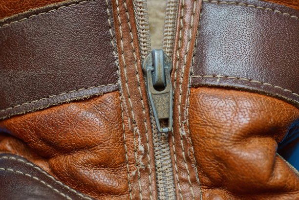 棕色皮革上的灰色金属拉链图片下载