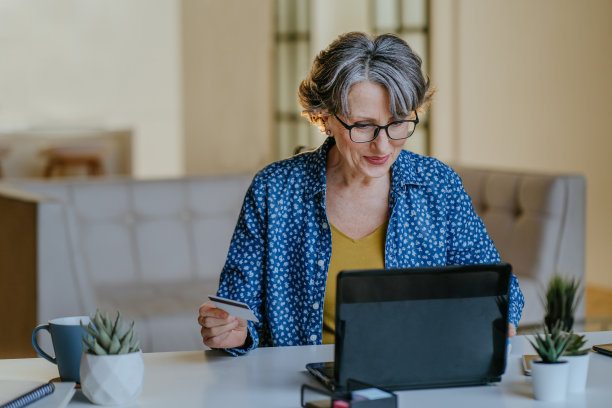 高级时尚女性用笔记本电脑和信用卡进行网上购物图片下载