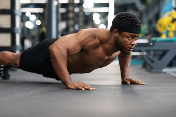 赤裸上身的黑人在健身房做俯卧撑图片下载