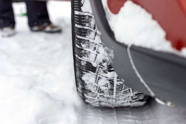 汽车轮胎在被雪覆盖的冬季道路上的照片。图片下载