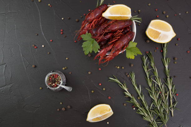 美味的水煮小龙虾放在一个白色盘子里，配上胡椒，柠檬和欧芹。为你的文本留出空间。图片下载