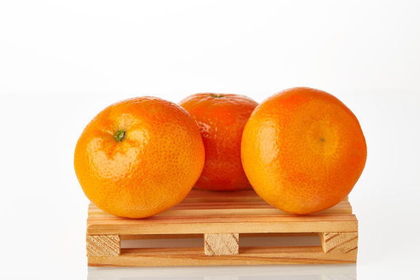 三个普通话在物流托盘上等待运输到目的地，隔离在白色的背景。水果出口或进口。图片下载