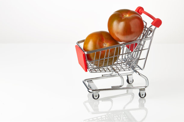 新鲜番茄和熊果在切菜车上孤立在白色背景。电子商务，网上购物，快递快。将水果放入篮子中图片下载