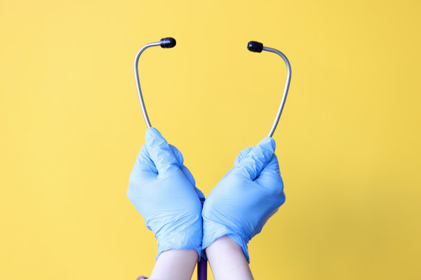 医生的手在手套拿近听诊器图片下载