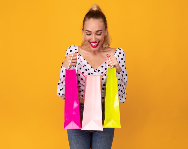 拿着购物袋往里面看的年轻女士图片下载