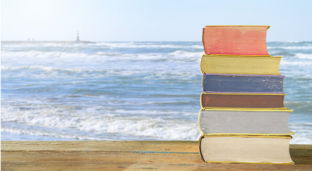 暑假在海边看书放松，书堆海景，象征性的自由拷贝空间图片下载