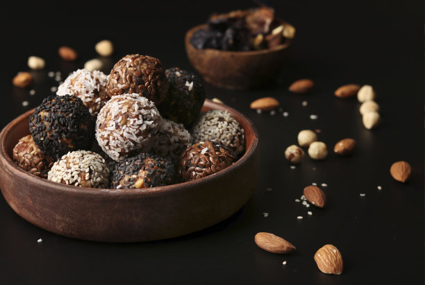 能量球坚果，燕麦和干果在一个棕色的盘子，在黑色的背景，水平格式图片下载