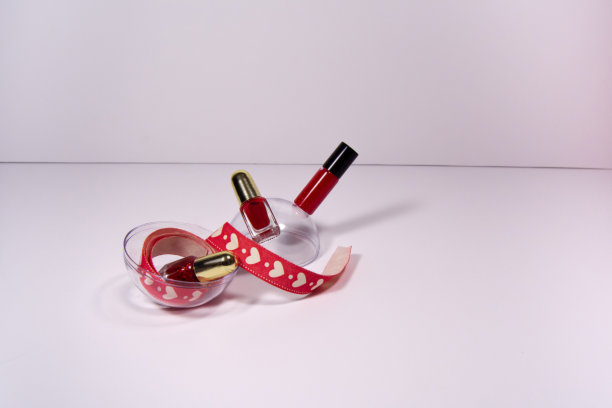 情人节的背景。白色背景上的红色口红和指甲油。图片下载