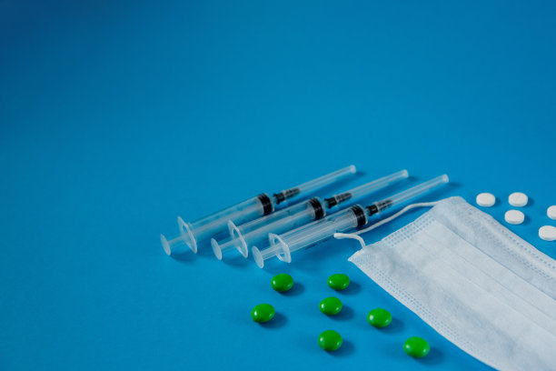 医用口罩，注射器和药丸，蓝色背景图片下载