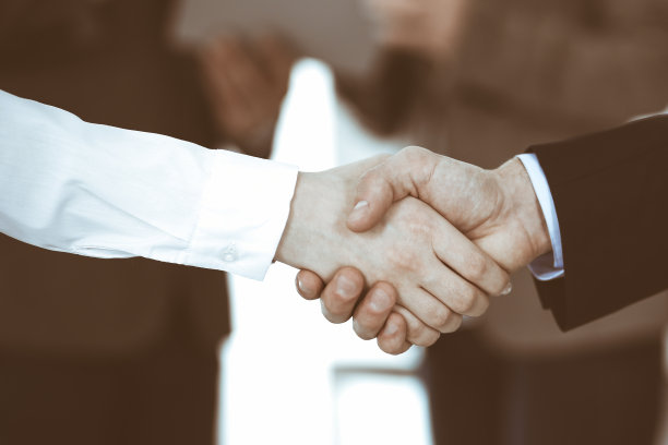 商务人士在会议或谈判后与同事握手。一群不知名的商人和女性在现代办公室。团队合作，伙伴关系和握手的概念，色调图片图片下载