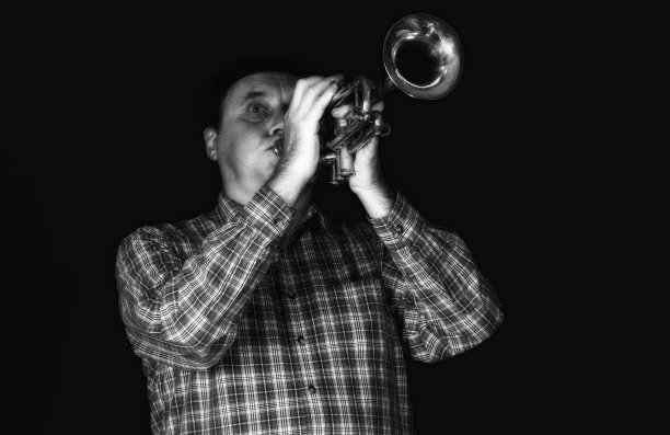 成熟的小号手在舞台上演奏乐器的肖像。图片下载