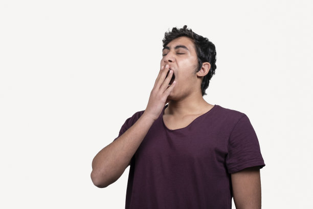 白色背景上打着呵欠的少年的肖像。图片下载