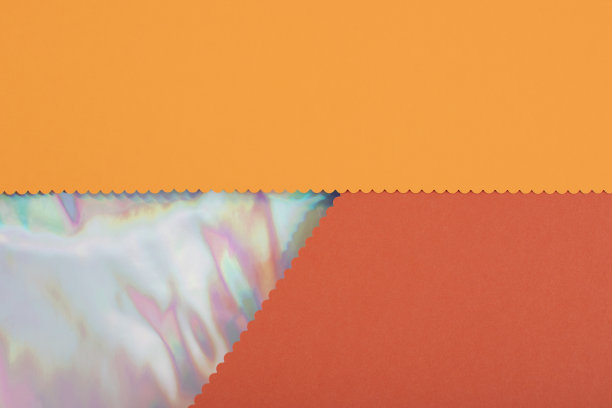 抽象橘色纸纹理与插入彩虹色全息箔。图片下载