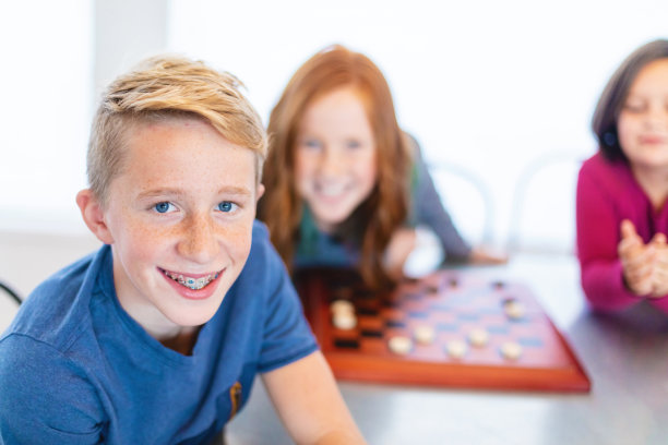 三个兄弟姐妹在一起玩跳棋图片下载