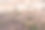 背景中的小山村在焦点和一个失焦的杏花在前景。图片下载