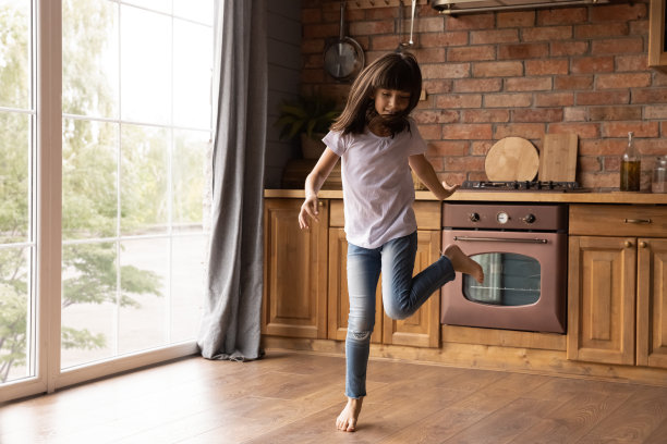 快乐可爱的小女孩在厨房跳舞，玩得很开心图片下载