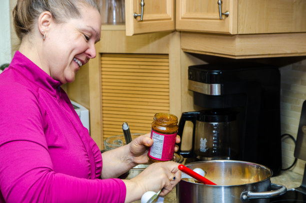 往锅里倒咖喱酱的女人图片下载
