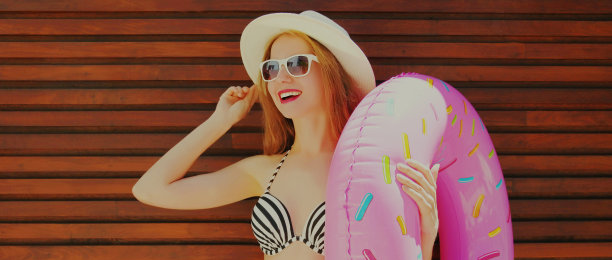 夏天的肖像快乐微笑的女人与充气圈戴着草帽在一个背景图片下载