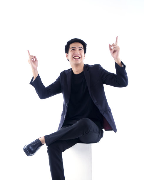 英俊的男人在黑色西装指向白色的背景图片下载