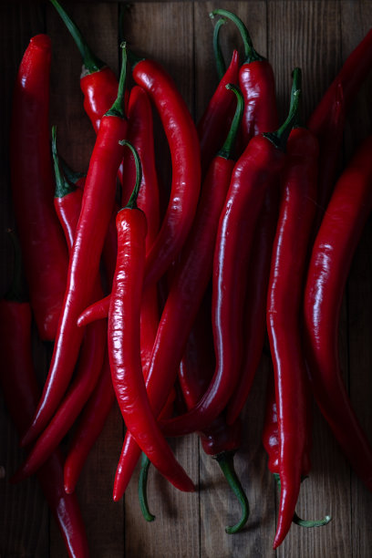 木头上放着新鲜的红辣椒。图片下载