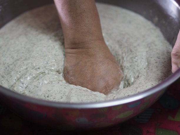 女人做馅金字塔甜点，馅金字塔，年糕，农历新年u2019年蛋糕，甜点糯米粉和糖制成，把香蕉叶小篮子蒸熟图片下载