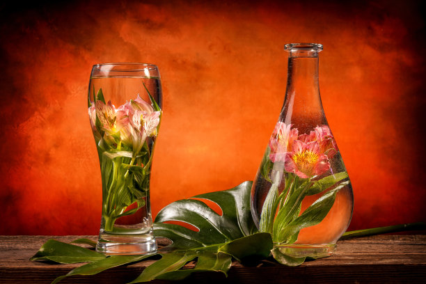 把鲜花和热带植物切成薄片，放在一张木桌上，放在一杯水里图片下载