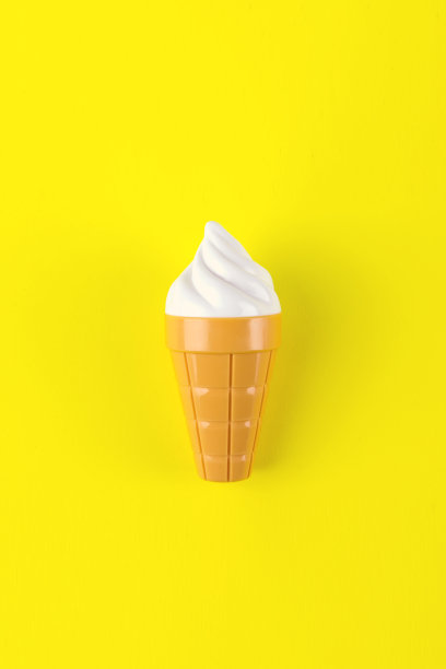 黄色背景上的一个塑料冰淇淋的特写。图片下载