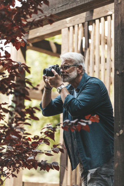 一位白发苍苍的老人正在拍摄大自然。退休的爱好图片下载