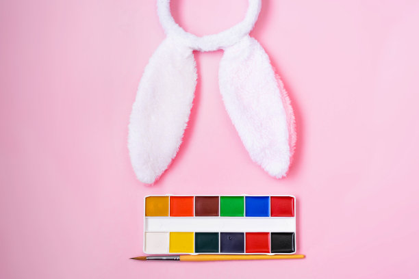 在粉红色的背景上画复活节兔子的耳朵。复活节，节日，教育理念。图片下载