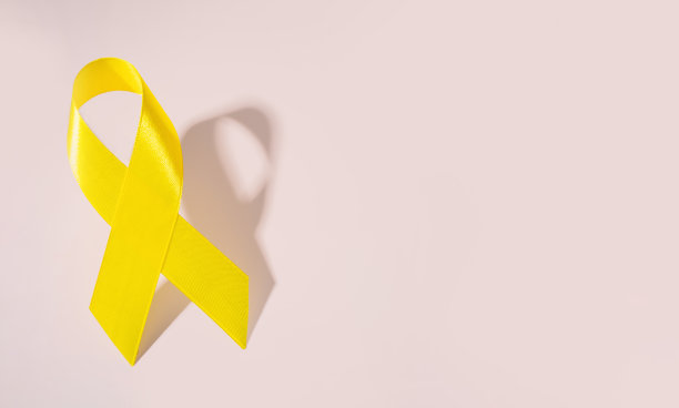 黄色癌症意识丝带作为儿童癌症意识的象征，以粉色为背景。本空间图片下载